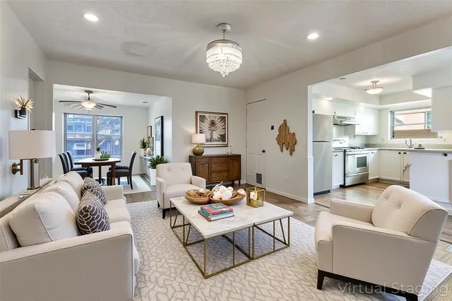 a living room with furniture kitchen view and a chandelier