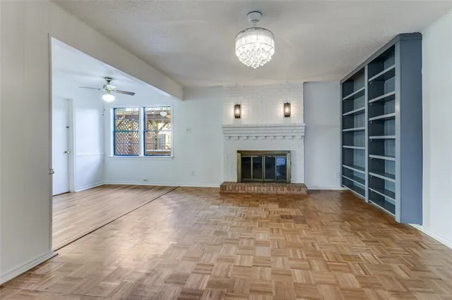 an empty room with windows and fireplace