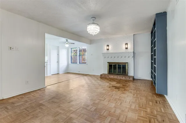 an empty room with windows and fireplace