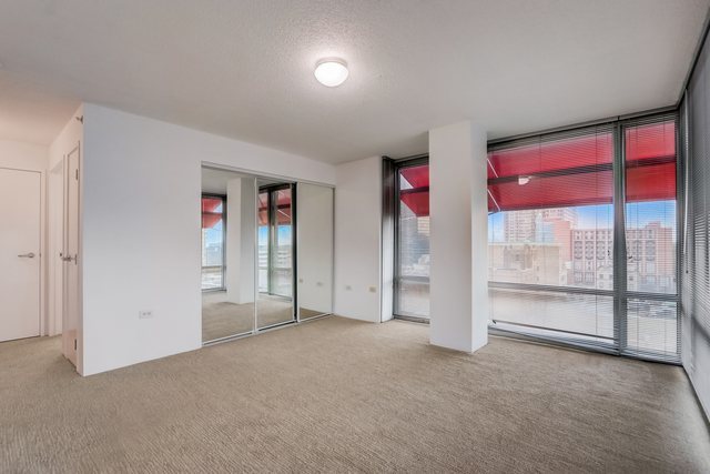 800 Elgin Road, Unit 1220 Evanston, IL 60201 - Photo 20 of 39 an empty room with sliding door and wooden floor