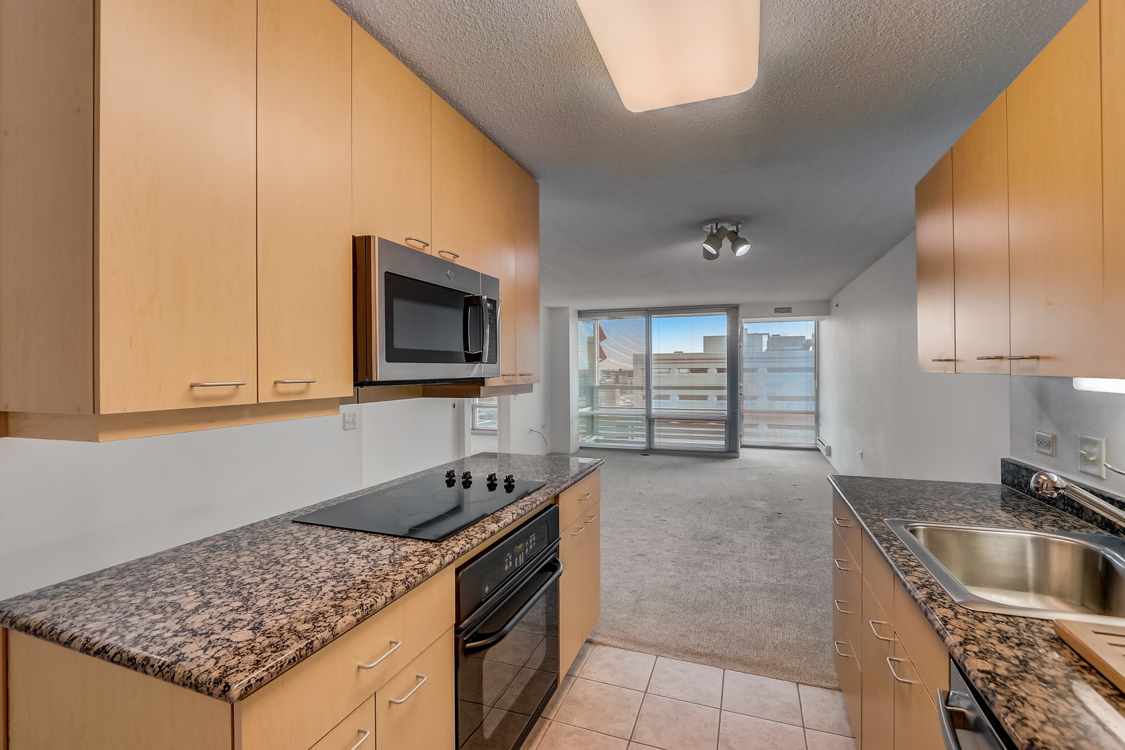 800 Elgin Road, Unit 1220 Evanston, IL 60201 - Photo 9 of 39 a kitchen with granite countertop a sink a stove and cabinets