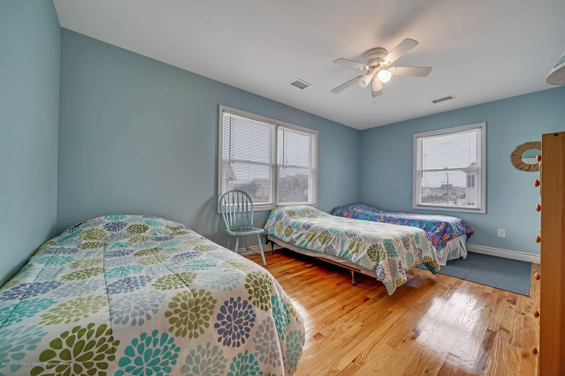195 Ketch Road Mantoloking, NJ 08738 - Photo 32 of 44 a bedroom with a bed and a chandelier