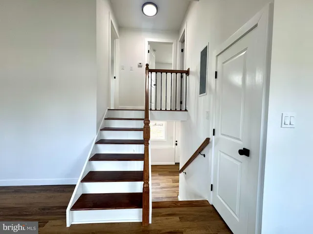 a view of entryway with wooden floor and white walls