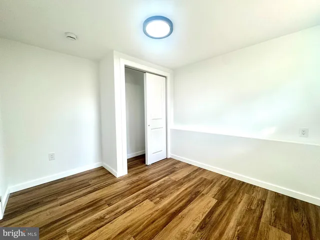 a view of a room with wooden floor and white walls