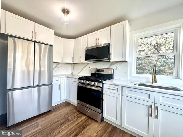 a kitchen with a stove a refrigerator and a sink