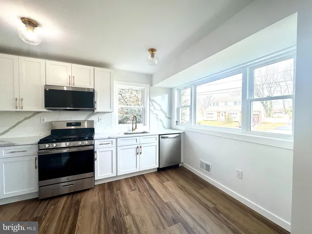 a kitchen with a stove a sink and a microwave