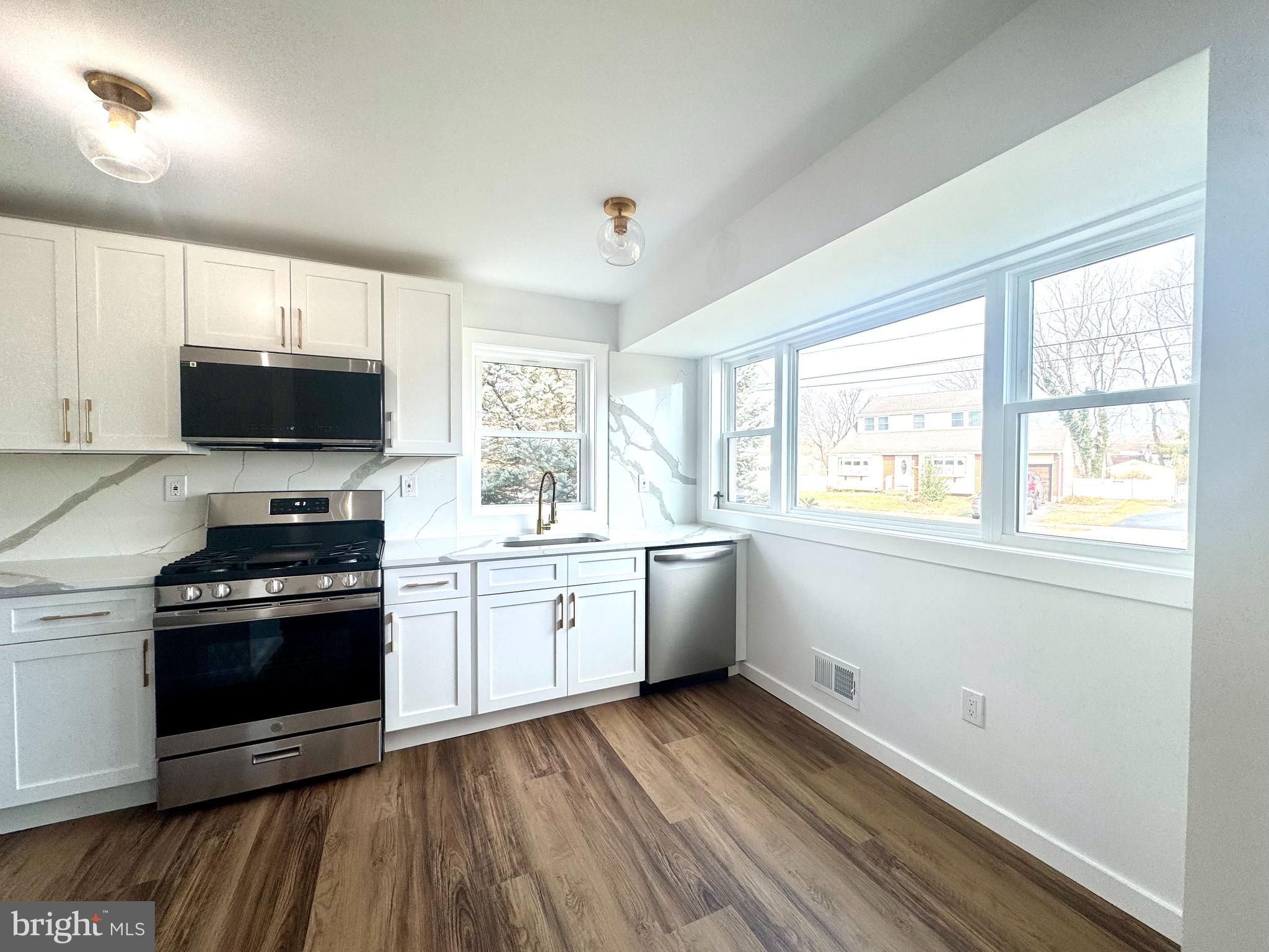 63 Gerard Road Hamilton, NJ 08620 - Photo 4 of 22 a kitchen with a stove a sink and a microwave