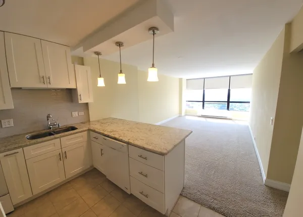 a kitchen with white cabinets and window