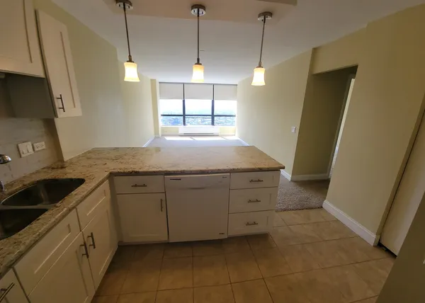 a view of an empty room with a kitchen