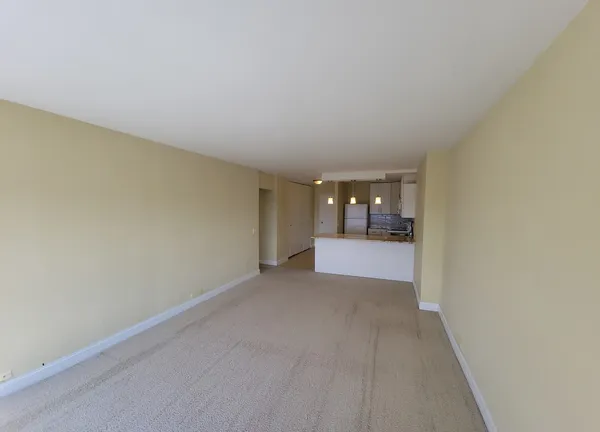 an empty room with chandelier fan and windows