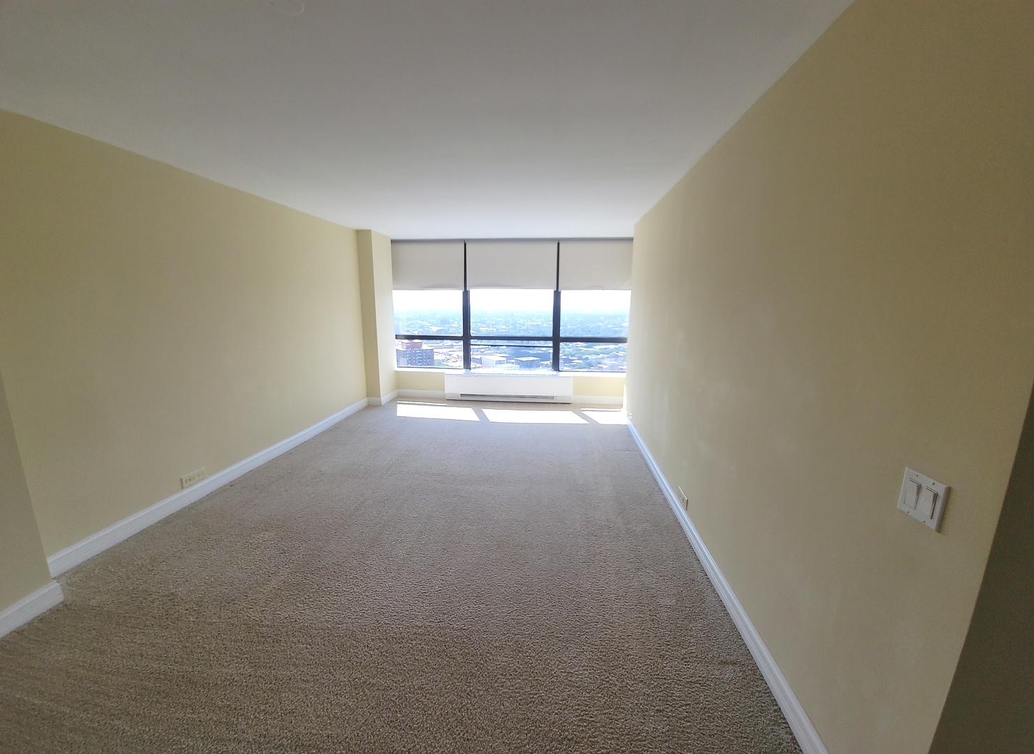 5415 North Sheridan Road, Unit 4414 Chicago, IL 60640 - Photo 9 of 23 an empty room with chandelier fan and windows