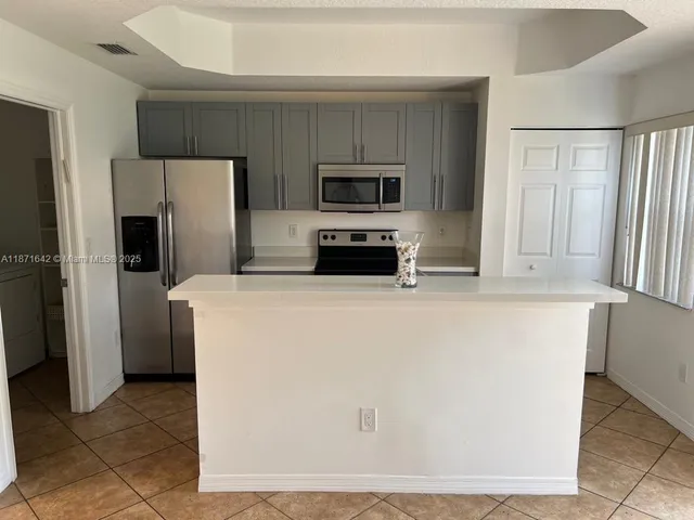 a kitchen with stainless steel appliances a refrigerator a stove top oven a sink and dishwasher