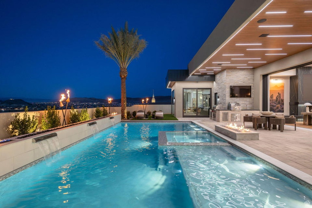 2867 East Granite Way St. George, UT 84790 - Photo 60 of 69 Resort-style pool area featuring integrated water features, an elevated fire pit, and an outdoor kitchen with stone accents