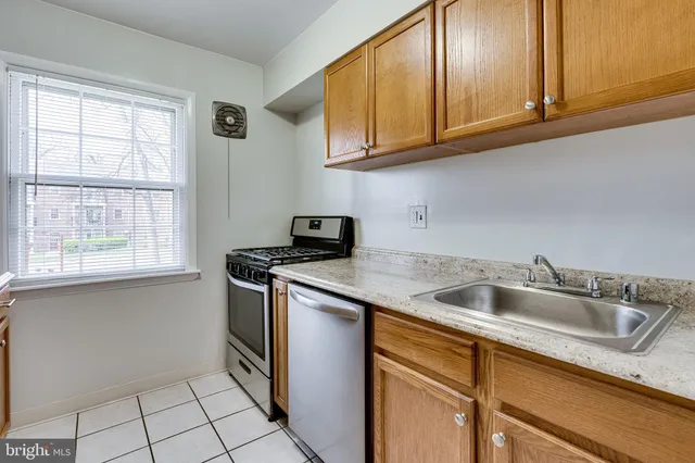 a view of a kitchen with white cabinets and a window