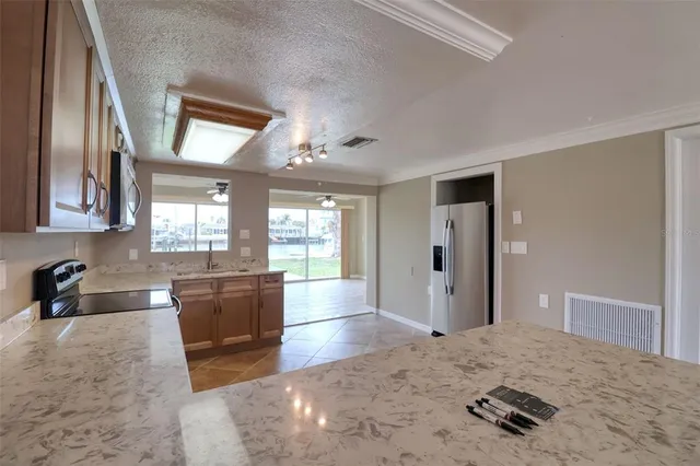 a kitchen with stainless steel appliances granite countertop a stove top oven a sink a counter top space and cabinets