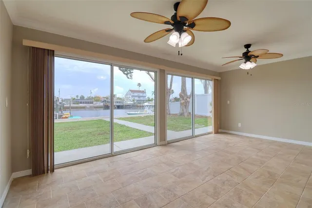 a view of an empty room with a chandelier fan