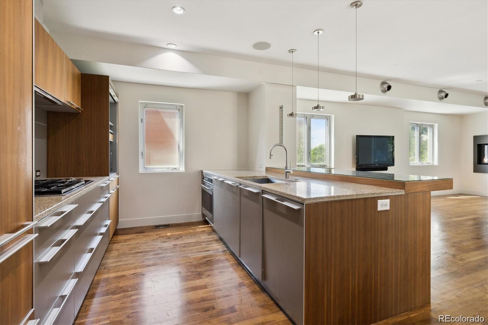2312 South University Boulevard Denver, CO 80210 - Photo 4 of 23 a kitchen with stainless steel appliances granite countertop a stove and a sink