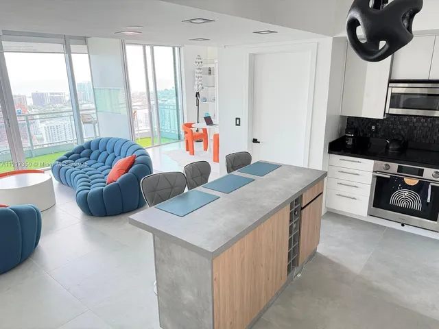 a living room with furniture and a floor to ceiling window