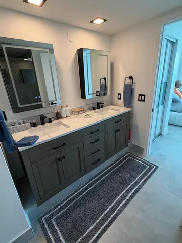 a bathroom with a double vanity sink and mirror
