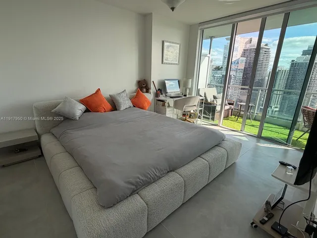 a living room with a couch and a floor to ceiling window