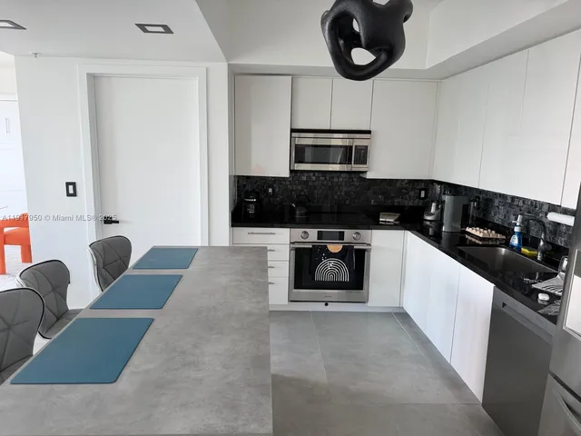 a kitchen with stainless steel appliances granite countertop a sink and cabinets