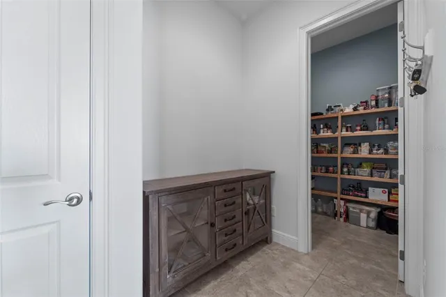 a living room with furniture a rug kitchen view and a window