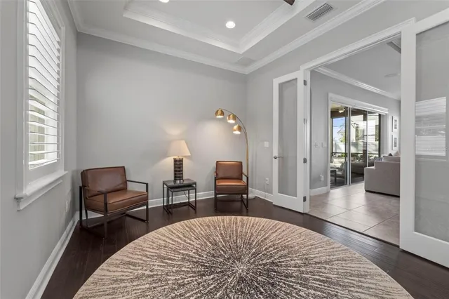 a spacious bedroom with a bed and a flat tv screen on dresser
