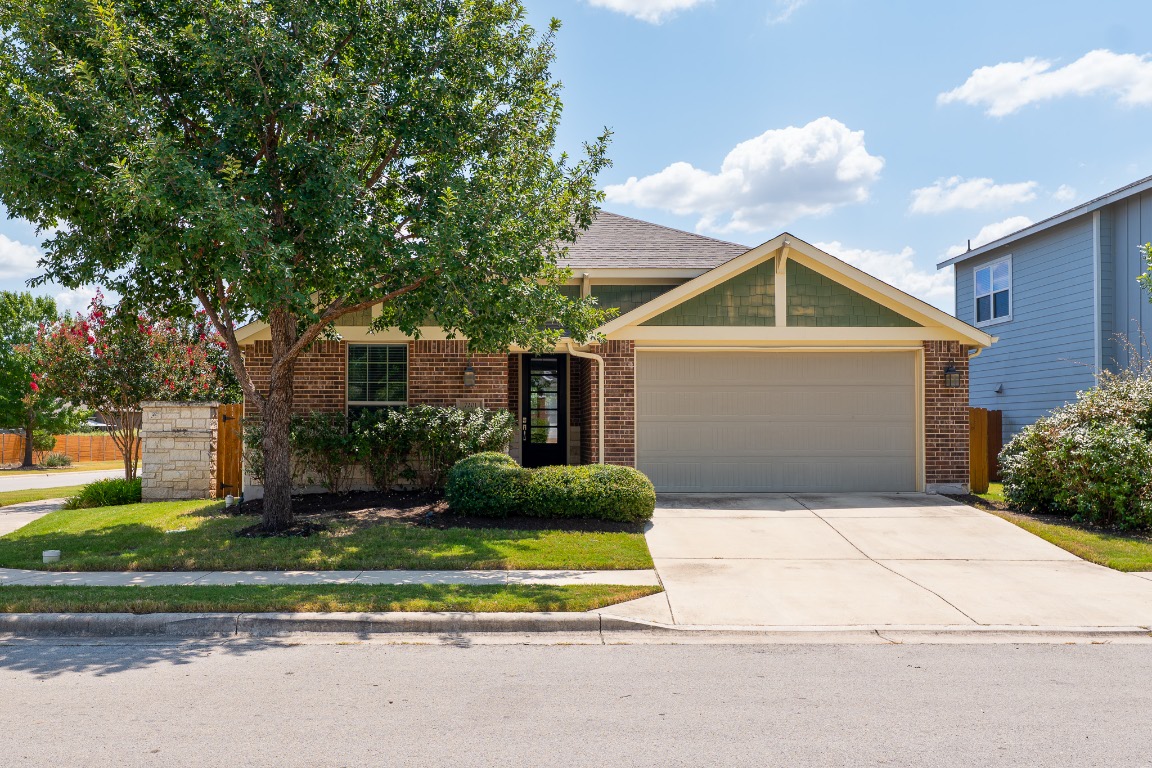 7201 Brick Slope Path Austin, TX 78744 - Photo 1 of 1 a front view of a house with a yard and garage