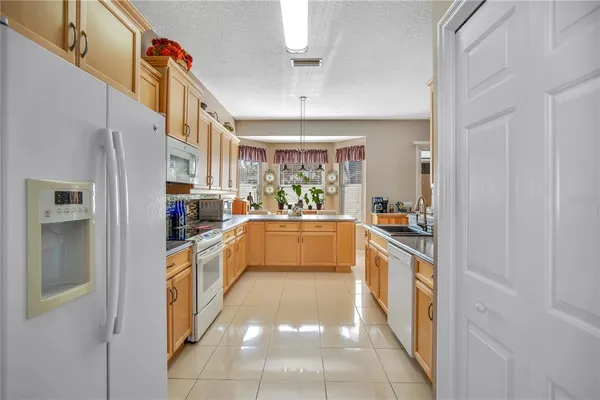 a large white kitchen with stainless steel appliances granite countertop lots of counter top space
