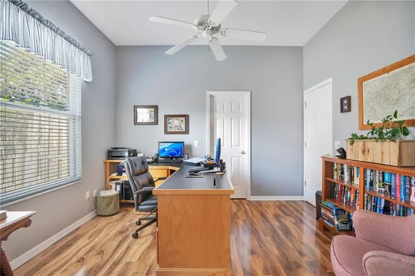 a view of a workspace with furniture and a window