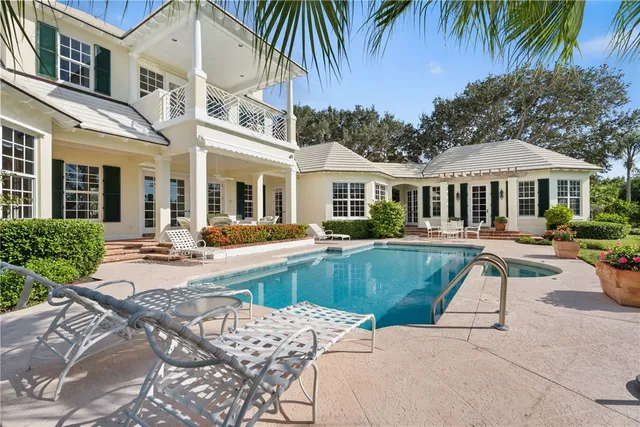 a view of a white house with a swimming pool and a chairs