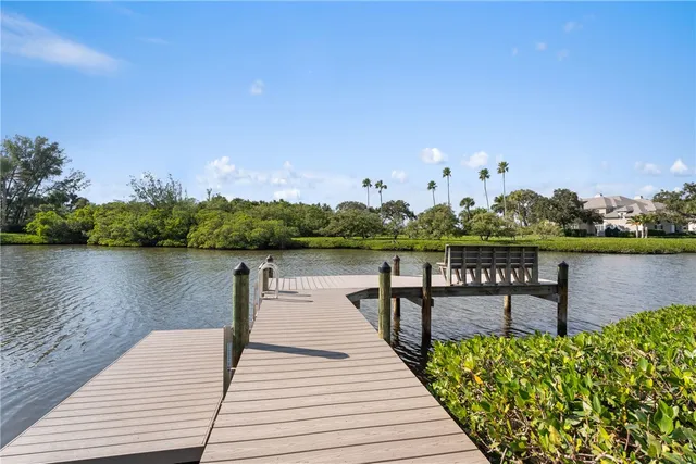 a lake view with a bench and trees in the background