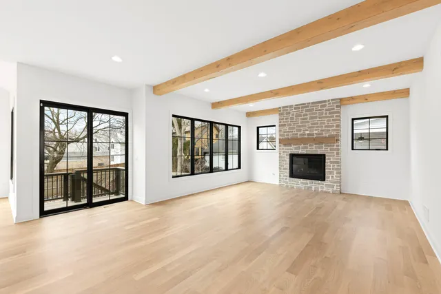 a view of an empty room with a fireplace and a window