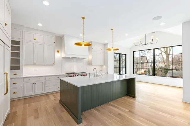 a kitchen with stainless steel appliances a sink stove and wooden floor