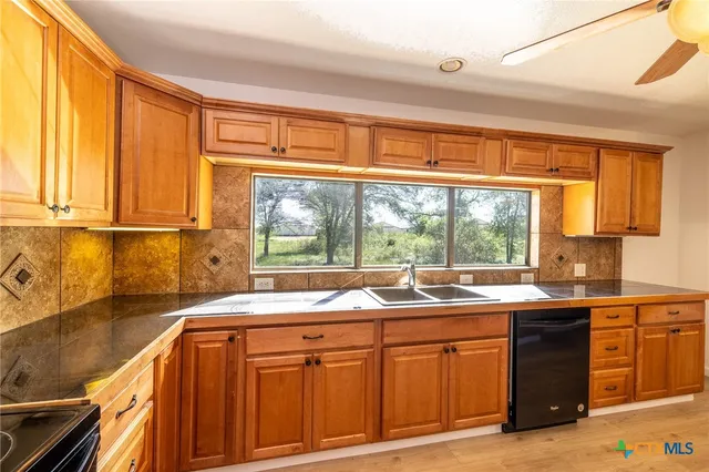 a kitchen with stainless steel appliances granite countertop a sink and a window