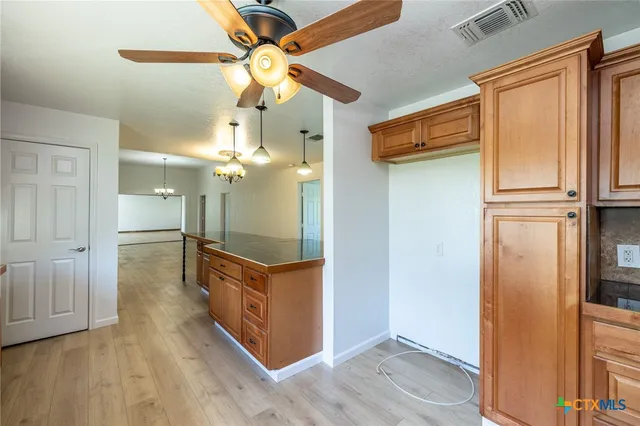 a view of a kitchen cabinets a chandelier and wooden floor