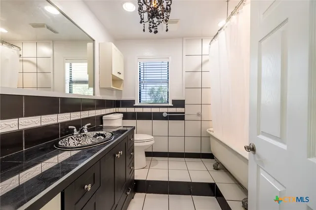 a kitchen with a sink a stove cabinets and a window