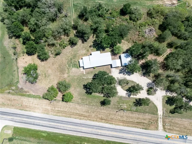 an aerial view of a house with a yard and greenery
