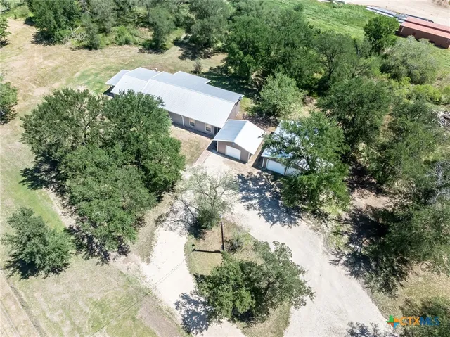 an aerial view of a house with a yard and lake view