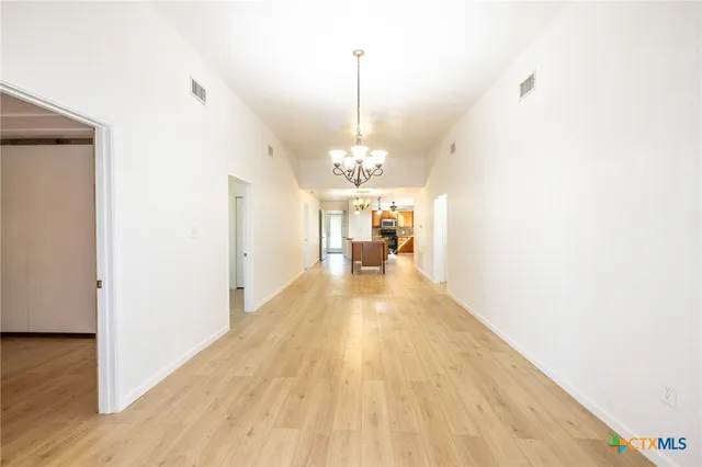 a view of a room with wooden floor windows and a chandelier