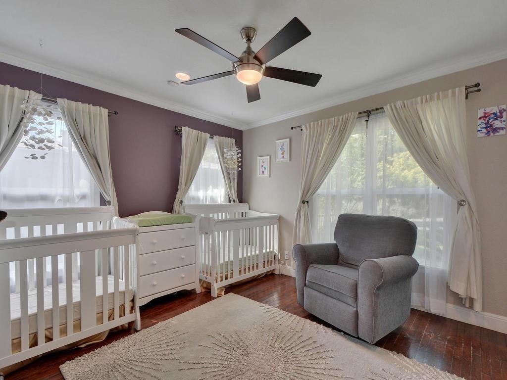 610 West N Loop Boulevard Austin, TX 78751 - Photo 20 of 29 Room featuring rich hardwood floors, ample natural light from multiple windows, and a ceiling fan with integrated lighting