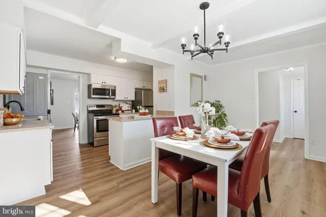 a view of a dining room with furniture a chandelier and wooden floor