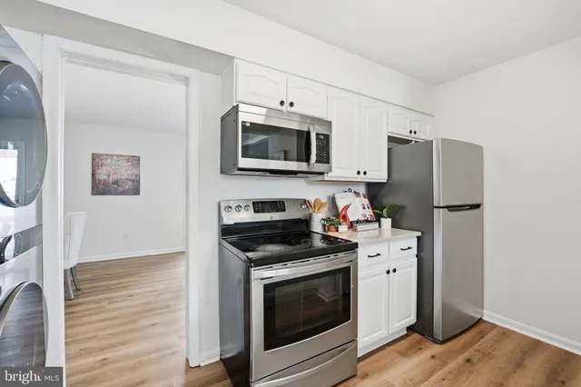 a kitchen with stainless steel appliances a stove microwave and refrigerator
