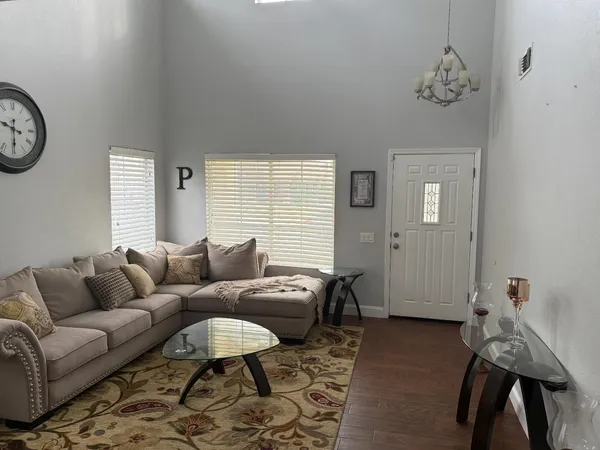 a living room with furniture a clock on wall and a window