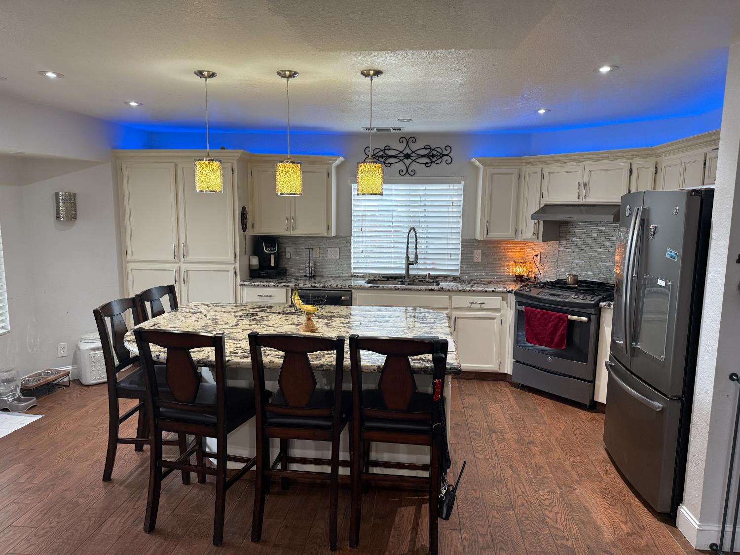 16432 Harmony Ranch Drive Delhi, CA 95315 - Photo 5 of 19 a kitchen with stainless steel appliances granite countertop a stove a refrigerator a kitchen island a dining table and chairs