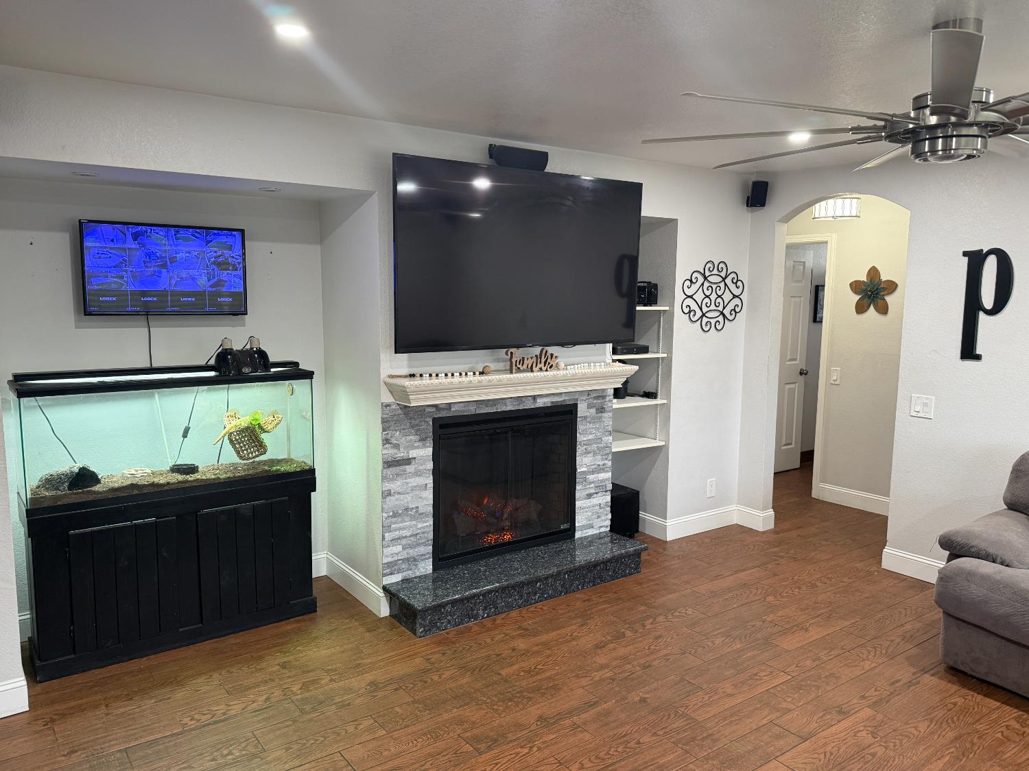 16432 Harmony Ranch Drive Delhi, CA 95315 - Photo 6 of 19 a living room with furniture a flat screen tv and a fireplace