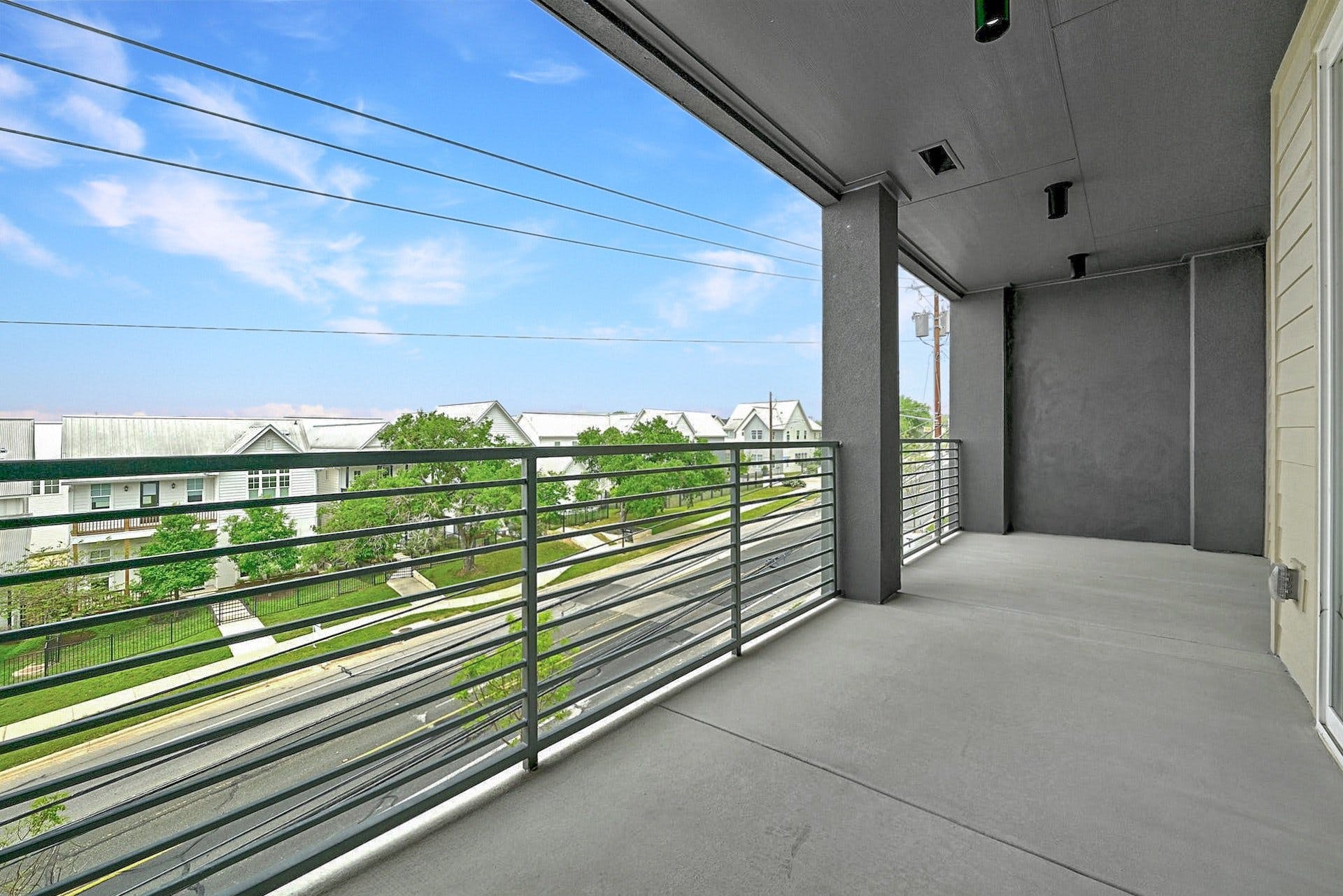 4801 Springdale Road, Unit 1301 Austin, TX 78723 - Photo 36 of 39 A spacious balcony offers elevated views of the vibrant neighborhood and street below.