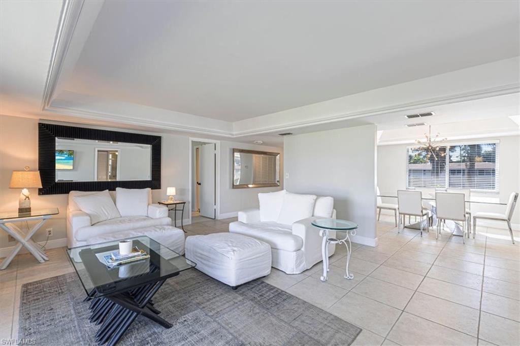 230 Albi Road, Unit 2494 Naples, FL 34112 - Photo 2 of 22 Tiled living room with baseboards and a tray ceiling