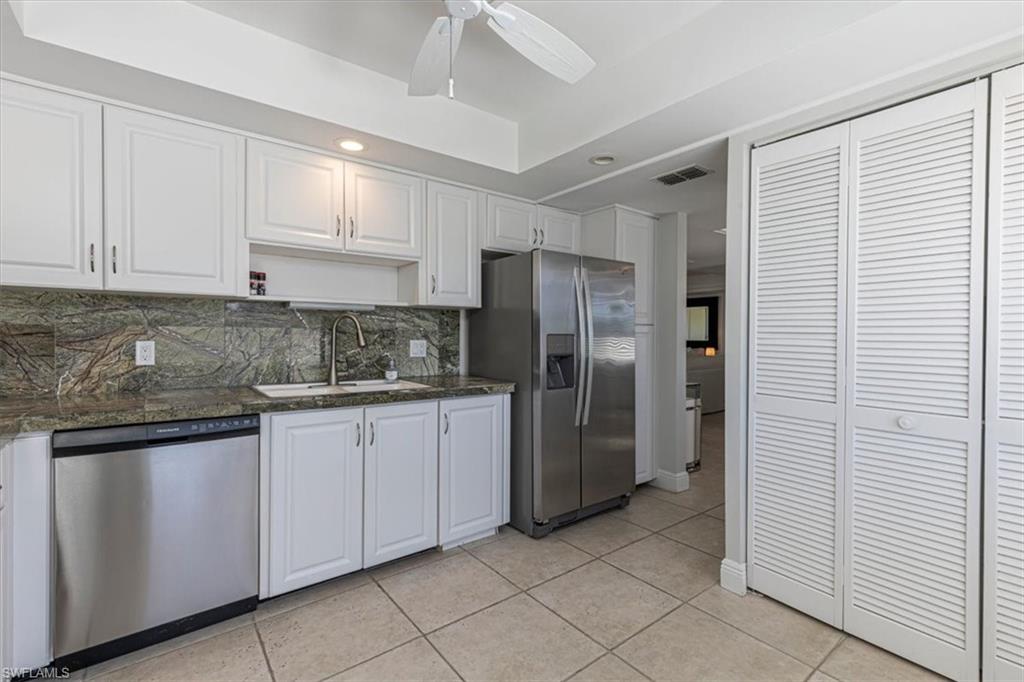 230 Albi Road, Unit 2494 Naples, FL 34112 - Photo 4 of 22 Kitchen featuring white cabinetry, appliances with stainless steel finishes, tasteful backsplash, open shelves, and light tile patterned floors