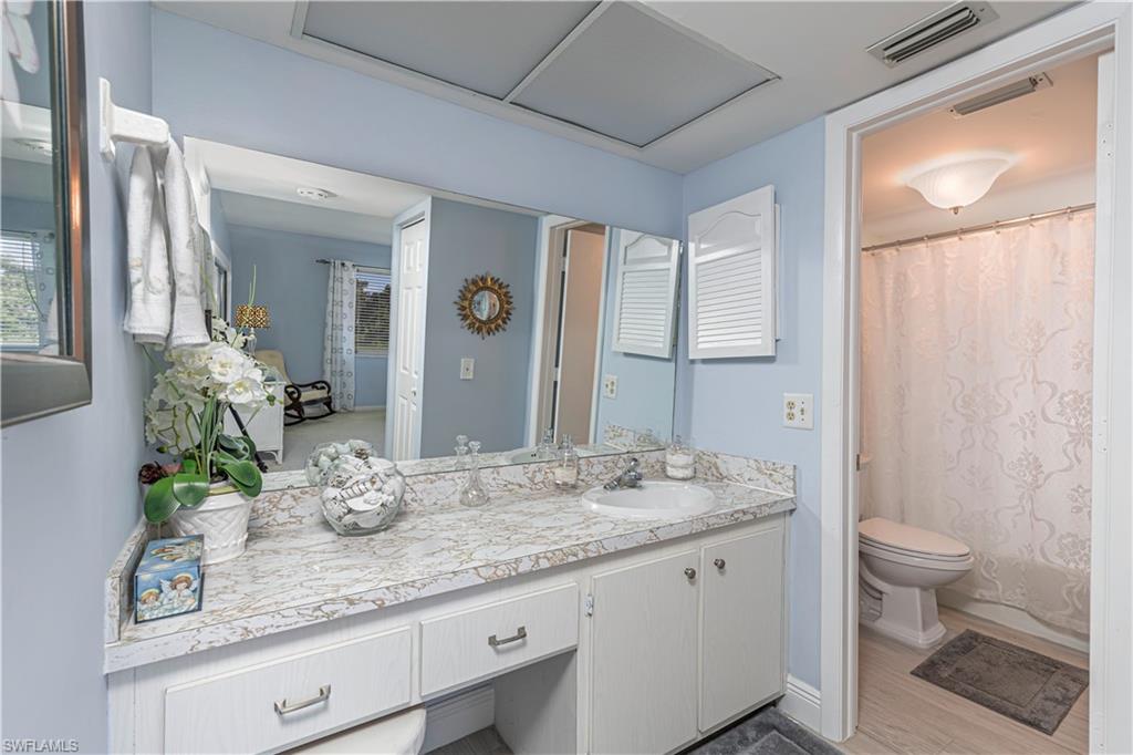 230 Albi Road, Unit 2494 Naples, FL 34112 - Photo 10 of 22 Bathroom with curtained shower, vanity, and light wood finished floors